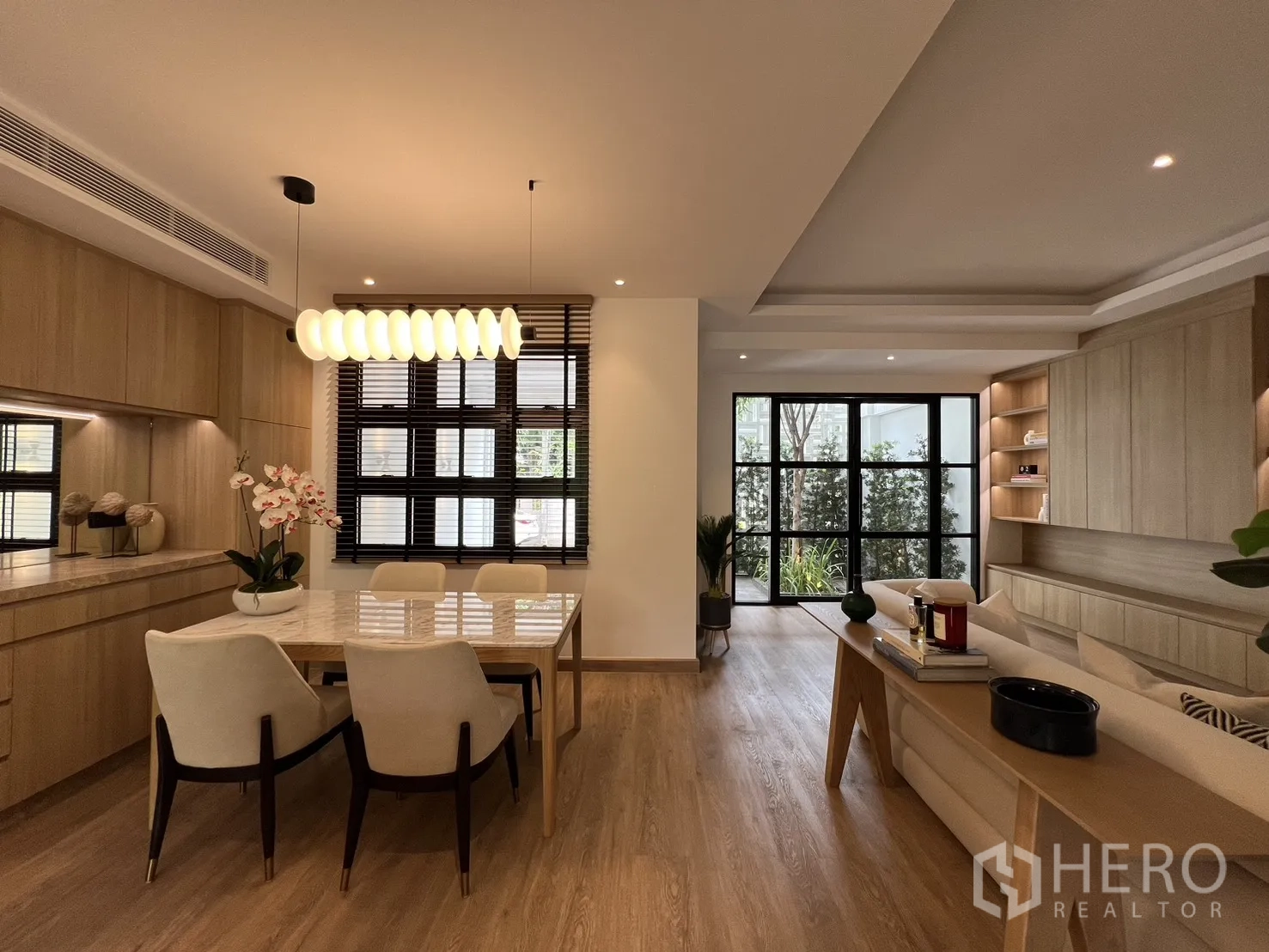 Townhouse for sale in Watthana, Bangkok - Open-plan interior with full-height mirror, island counter and dining table.
