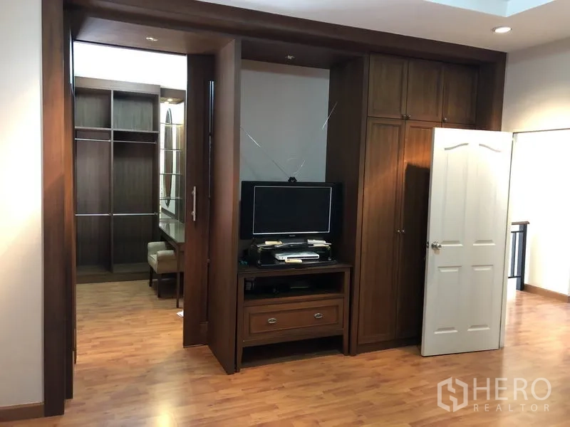 Detached House for rent or sale in Bang Kapi, Bangkok - Walk-in closet area with built-in wardrobes and a TV cabinet.