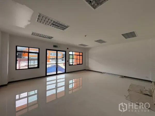 Factory for rent in Bang Pakong, Chachoengsao - Bright ground‑floor office with tiled flooring, glass doors and black‑framed windows.