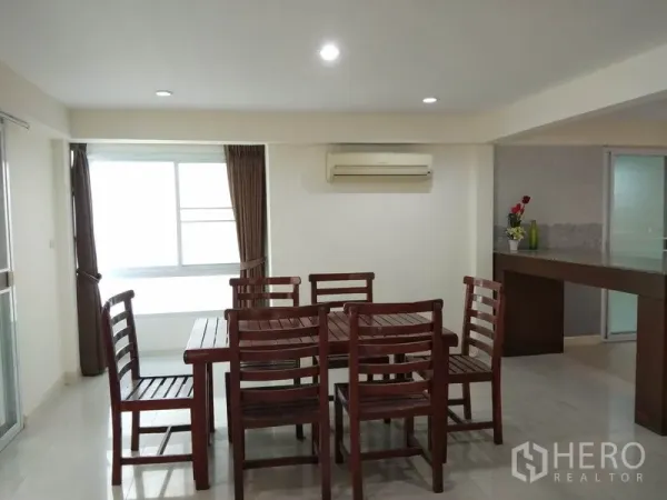 Detached House for rent in Watthana, Bangkok - Dining area with wooden table and chairs, air conditioning and a wide window.