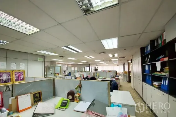 Office Space for rent in Ratchathewi, Bangkok - Spacious office area with multiple cubicles, built-in cabinets and suspended ceiling lights creating a bright work environment.