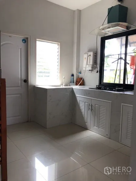 Detached House for sale in Lam Luk Ka, Pathum Thani - Second kitchen with window, cooktop and white cabinetry.