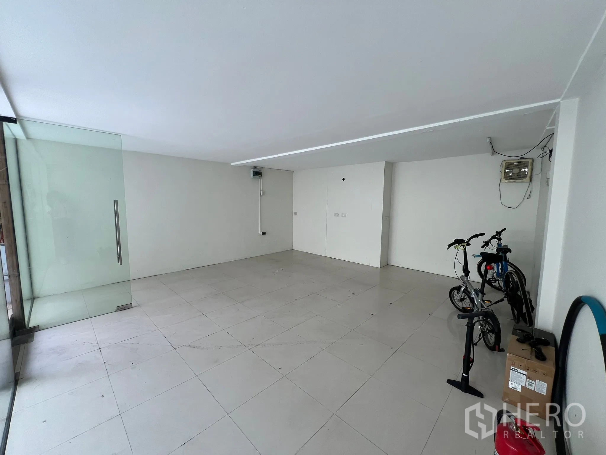 Retail Space for rent in Watthana, Bangkok - Spacious open-plan shop area with full-height glass entrance and bicycles at the side.