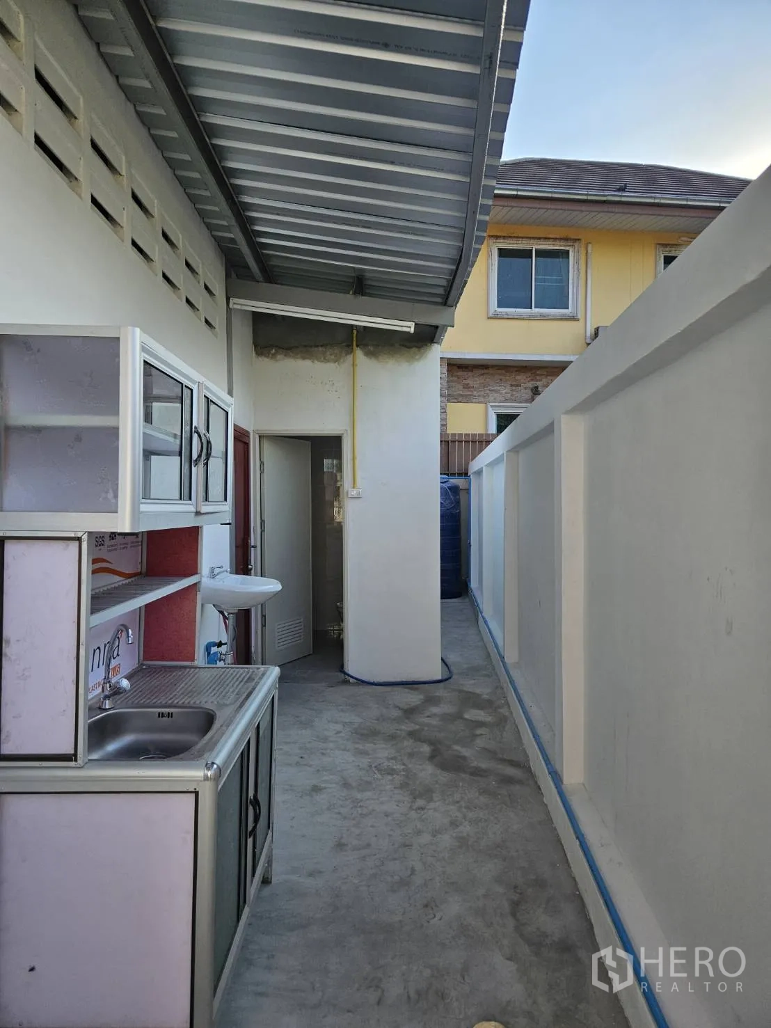 Warehouse for rent in Mueang Samut Prakan, Samut Prakan - Covered side utility area with sink and doorway to a restroom.