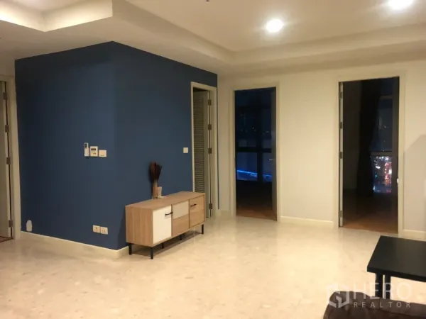 Condominium for sale in Khlong Toei, Bangkok - Hallway with a blue accent wall, console cabinet and doors leading to bedrooms.