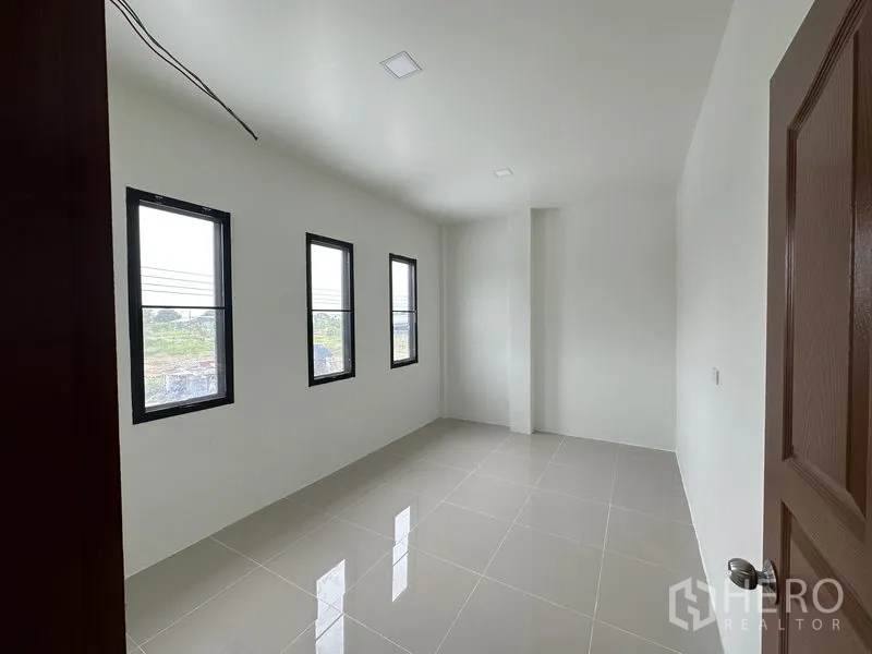 Warehouse for rent in Lam Luk Ka, Pathum Thani - Bright upstairs office room with three windows and tiled floor.