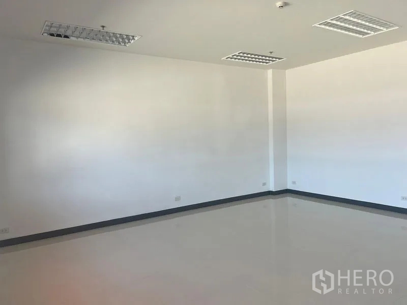 Factory for rent in Bang Pakong, Chachoengsao - Bright office room with white walls, tiled floor and recessed fluorescent lighting.