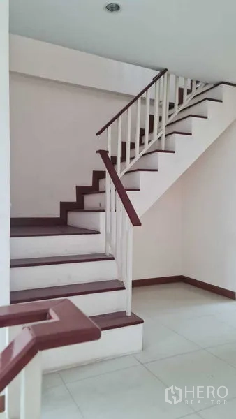Townhouse for  in Lam Luk Ka, Pathum Thani - L-shaped staircase feature with white railing on the ground floor.