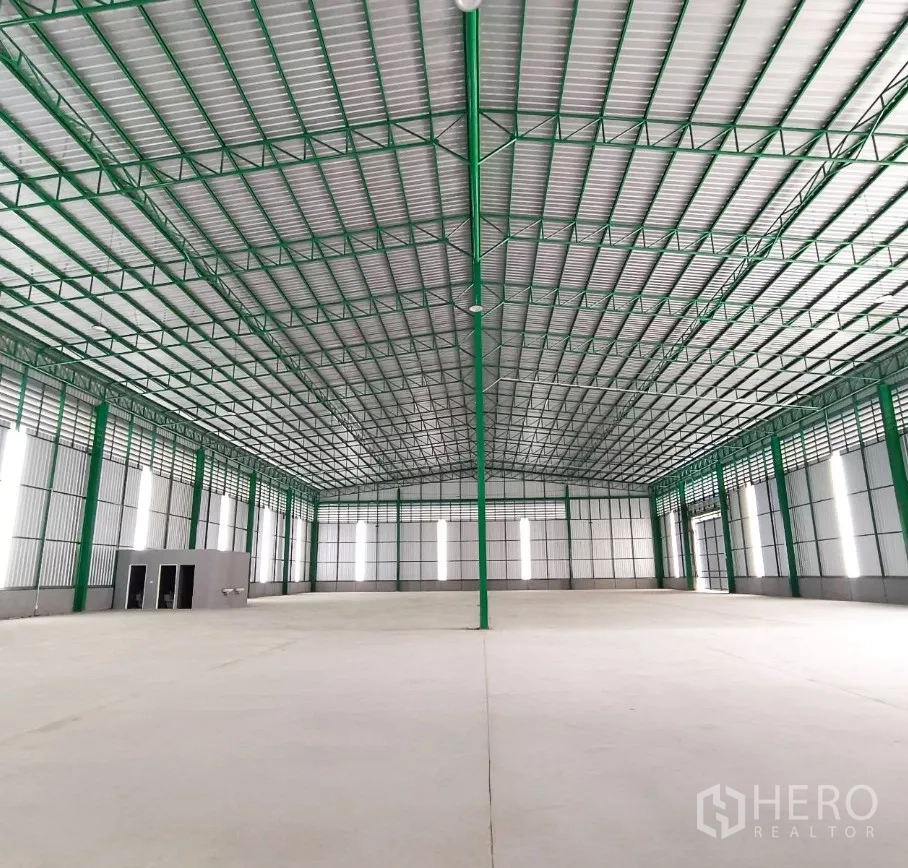 Warehouse for rent in Bang Bon, Bangkok - Large open-plan warehouse with central column, polished floor and insulated metal roof.
