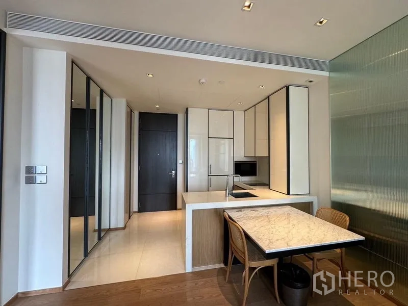 Condominium for rent - Compact kitchen with island, marble dining table and full-height storage cabinets.