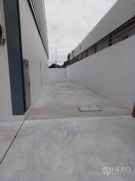 Warehouse for rent in Khlong Toei, Bangkok - Side service lane with concrete surface along the warehouse wall.