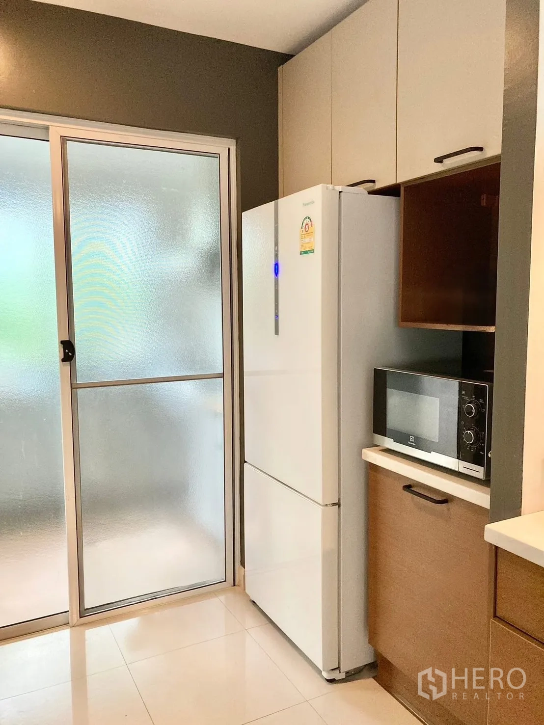 Detached House for rent in Prawet, Bangkok - Pantry zone with refrigerator, microwave and frosted glass sliding door.