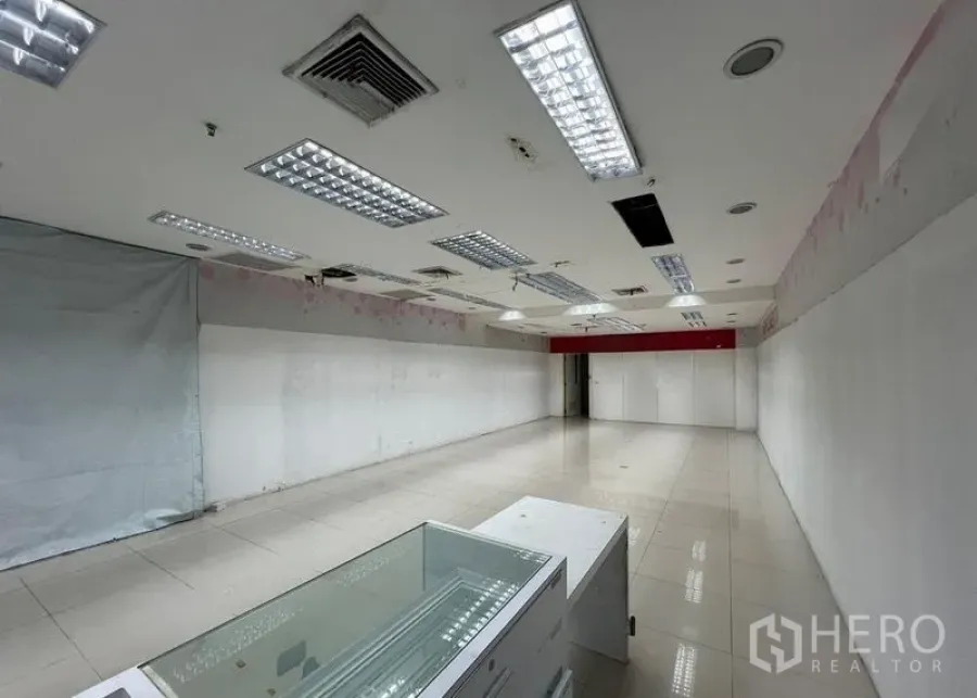 Retail Space for rent - Retail shop space with a glass display counter, white partition walls and recessed lighting in an open layout.