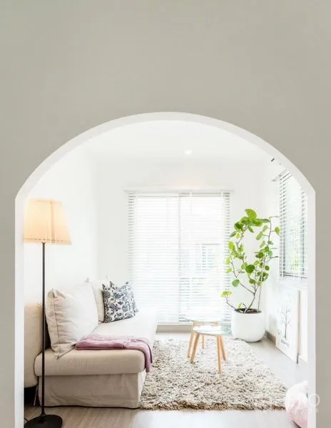 Detached House for rent - Small reading nook through an arched doorway with sofa, rug, floor lamp, and potted plant.
