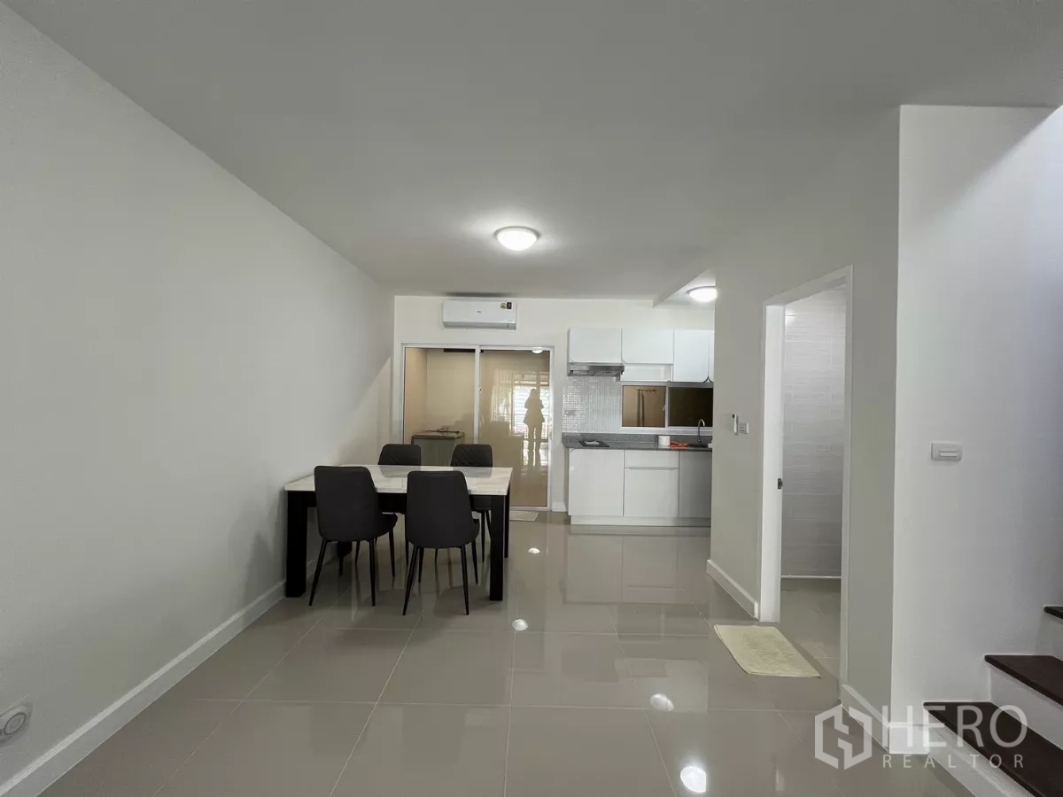 Townhouse for rent in Bang Kapi, Bangkok - Dining space for four adjacent to white kitchen.