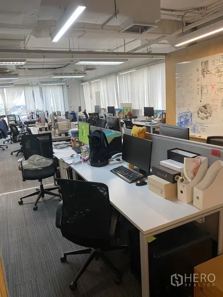 办公空间 出租在Khlong Toei, Bangkok - 开放式办公区，成排工位、地毯地面与配百叶的大窗户，采光充足。