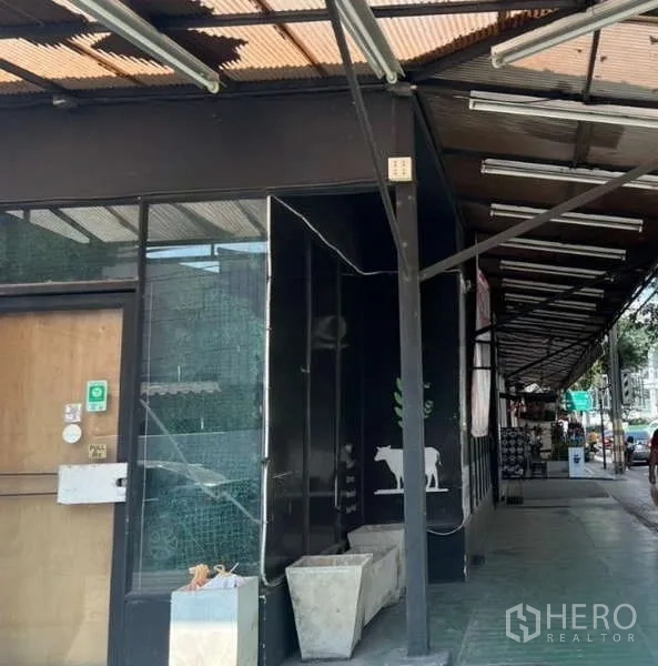 Retail Space for rent in Suan Luang, Bangkok - Street-level retail unit in Suan Luang with black facade, glass shopfront, covered walkway and planters.