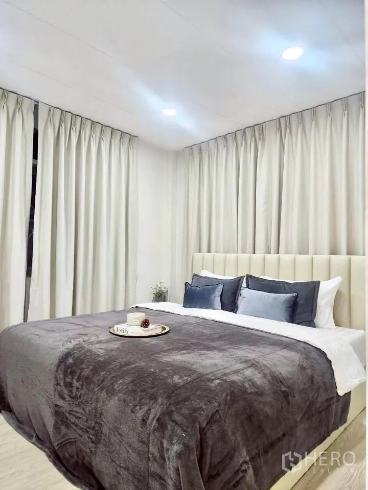 Detached House for rent in Huai Khwang, Bangkok - Bedroom with padded headboard, surrounding curtains and decorative tray on bed.