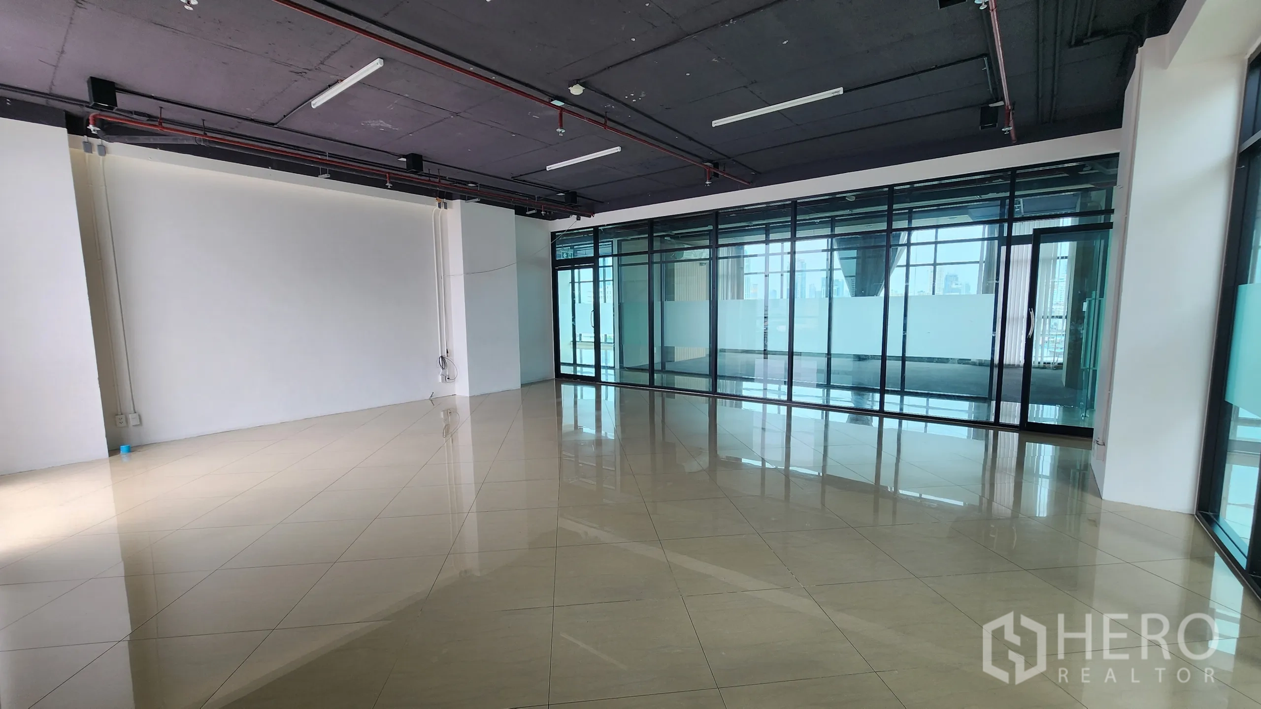 Office Space for rent in Yan Nawa, Bangkok - Spacious open office with polished tile floors and exposed ceiling lights.