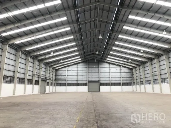 Factory for rent in Wang Noi, Phra Nakhon Si Ayutthaya - Open factory floor with clear-span steel structure and a central roller shutter at the far wall.