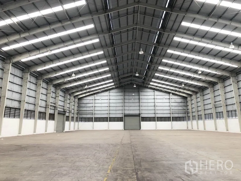Factory for rent in Wang Noi, Phra Nakhon Si Ayutthaya - Open factory floor with clear-span steel structure and a central roller shutter at the far wall.