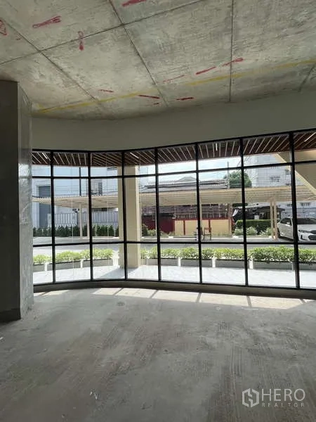Retail Space for rent in Phra Khanong, Bangkok - Open interior showing expansive floor-to-ceiling glazing and landscaped planters outside.