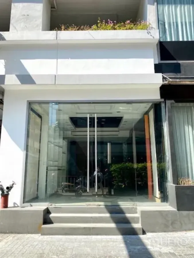 零售空间 出租在Pathum Wan, Bangkok - 一层零售店入口，通高玻璃立面与双开玻璃门，前方台阶，现代白色外立面