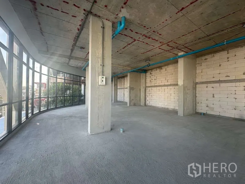 Retail Space for rent in Phra Khanong, Bangkok - Bright corner area with wraparound glazing, tall ceilings, and city outlook in a raw retail space.
