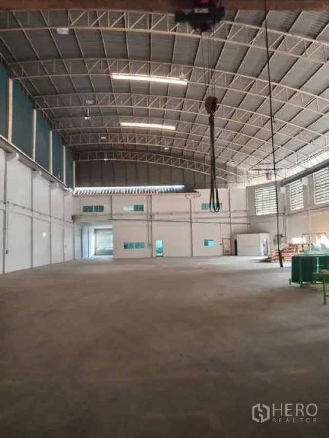 工厂 出租在Mueang Samut Prakan, Samut Prakan - 仓库式厂房内景，吊钩行车、夹层办公室及宽阔混凝土地面。