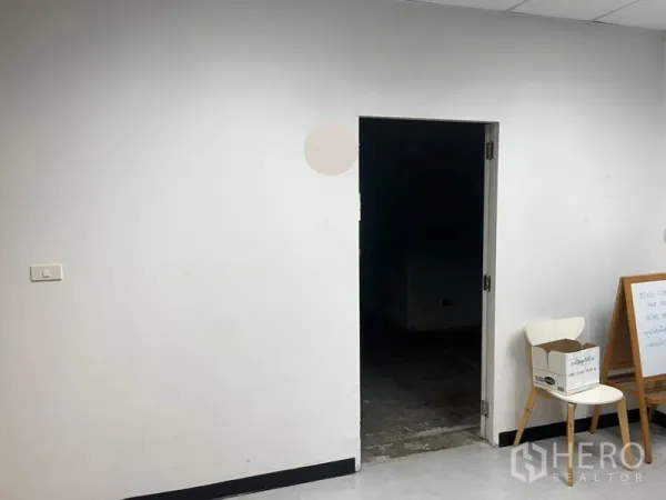 Office Space for rent - Simple entry area with white walls and a doorway leading into the unfinished office floor.
