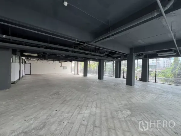 Retail Space for rent in Watthana, Bangkok - Spacious open-plan retail floor with exposed ceiling and wraparound windows.