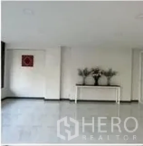 Home Office for rent in Wang Thonglang, Bangkok - Minimalist open plan room with decorative console table and wall art.