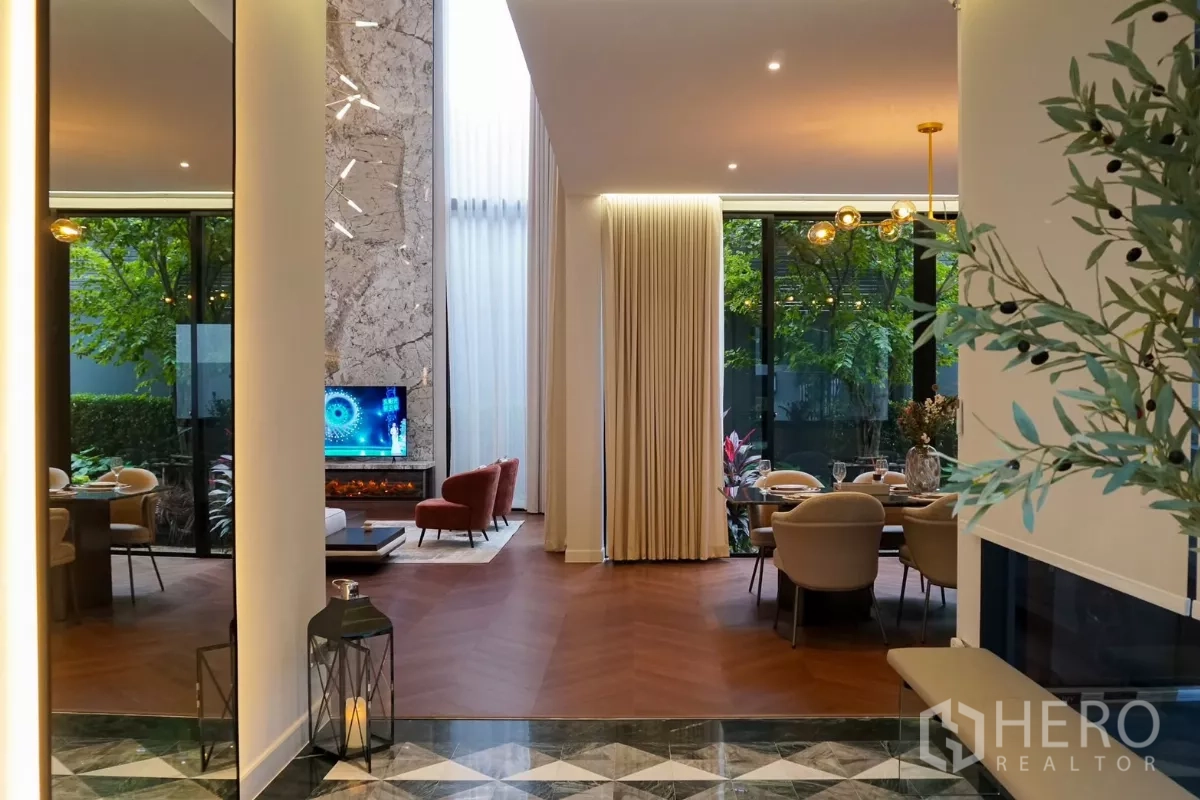 Detached House for rent or sale in Bang Kapi, Bangkok - View from the entry hall into the airy living and dining framed by tall curtains.