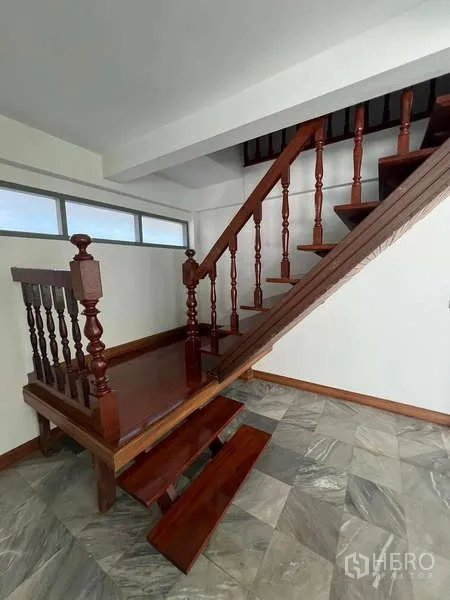 Detached House for rent in Bang Na, Bangkok - Wooden staircase with classic balustrade leading to the upper floor.