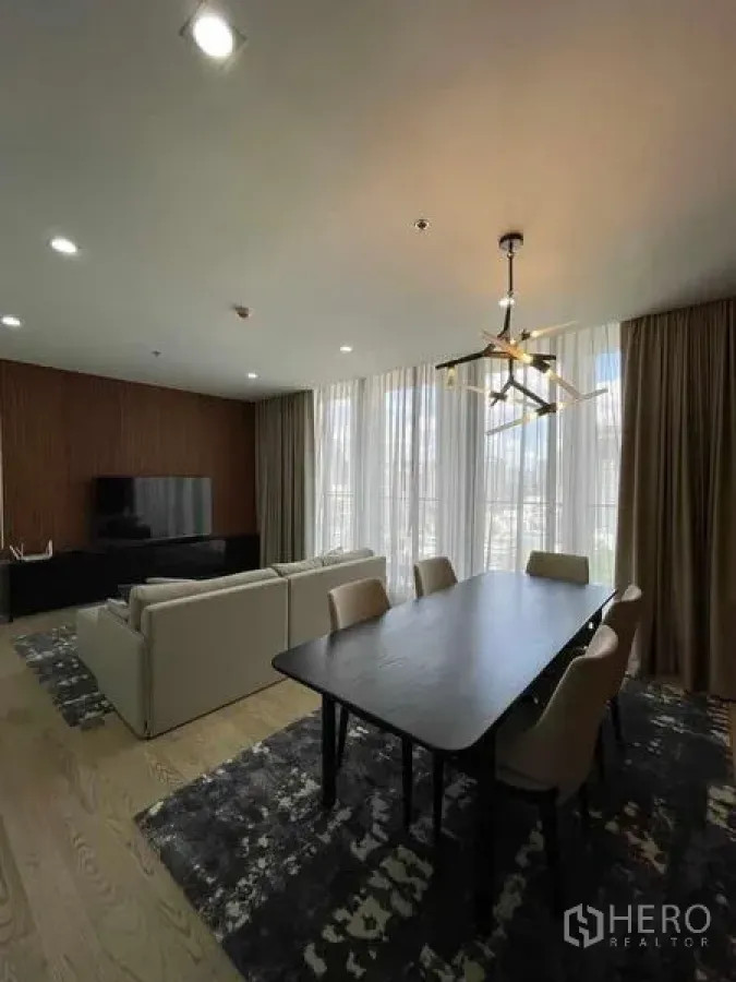 Condominium for rent in Pathum Wan, Bangkok - Spacious living–dining room with large windows, modern chandelier and city views.