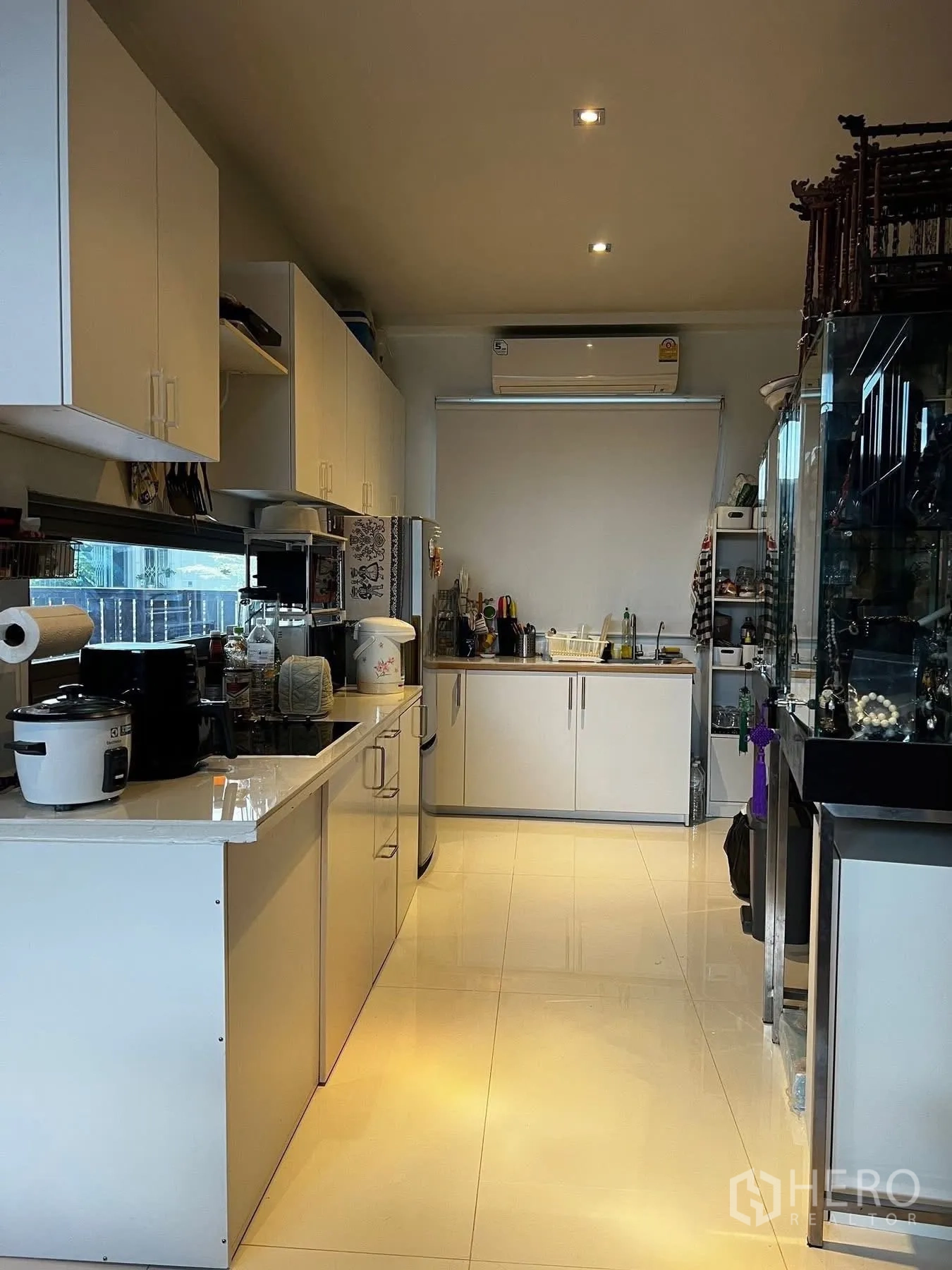 联排别墅 for rent or sale in Watthana, Bangkok - 明亮厨房，白色橱柜与台面、电器齐全。