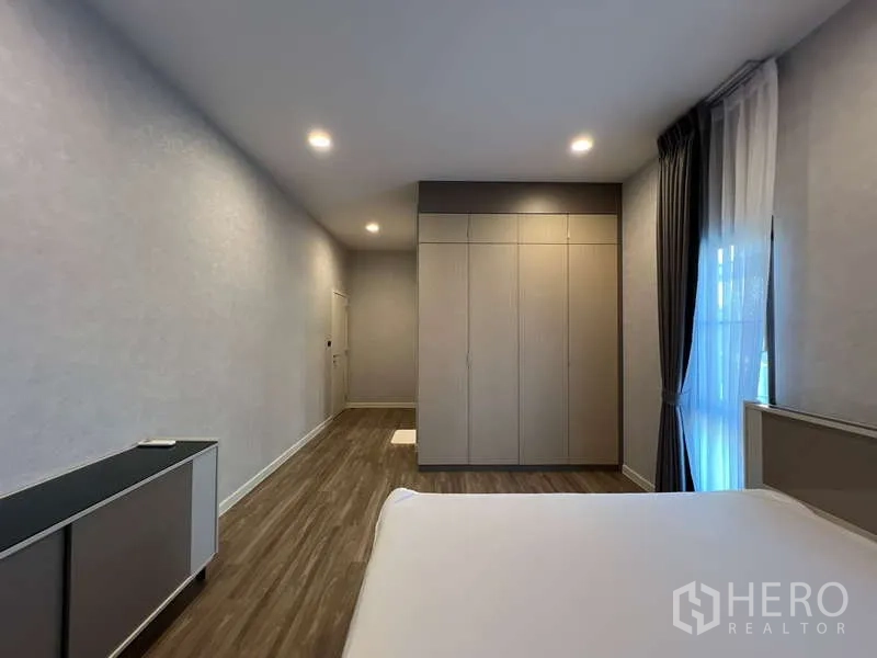 Detached House for rent in Bang Kapi, Bangkok - Large bedroom with fitted wardrobe and soft lighting.