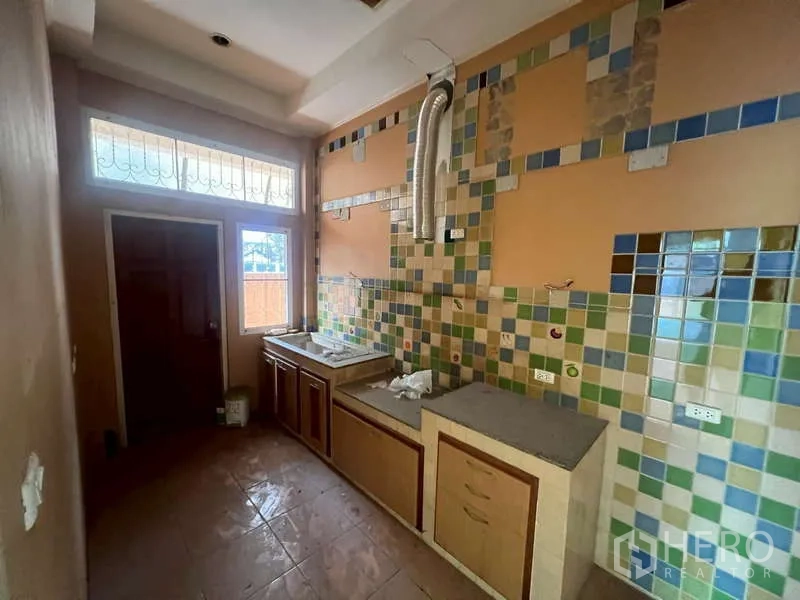 Detached House for rent in Watthana, Bangkok - Compact Thai kitchen with colorful mosaic tiles and a vent pipe.