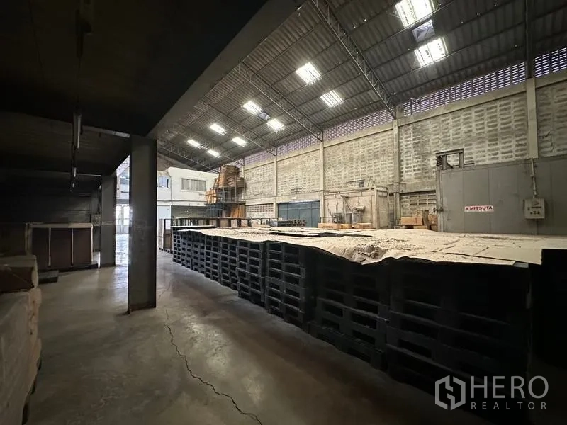 Factory for rent in Lam Luk Ka, Pathum Thani - Covered production area with concrete floor and tall ventilated walls.