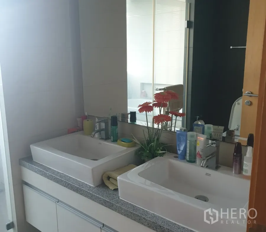 Condominium for sale in Khlong Toei, Bangkok - Modern bathroom with double rectangular sinks, granite counter and large mirror.