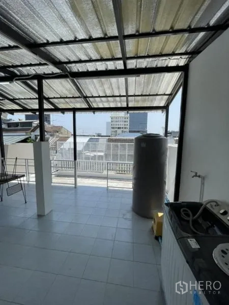 Townhouse for rent in Phra Khanong, Bangkok - Covered rooftop terrace with city views, water tank and laundry area.