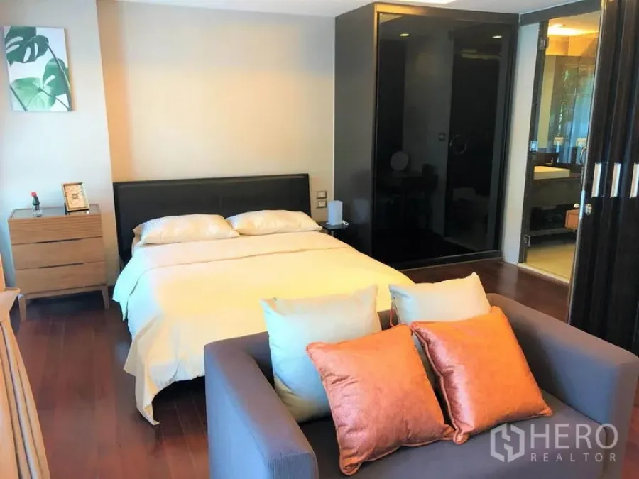Condominium for rent in Watthana, Bangkok - Bright bedroom with queen bed, two-seat sofa and sliding-door access to the bathroom.