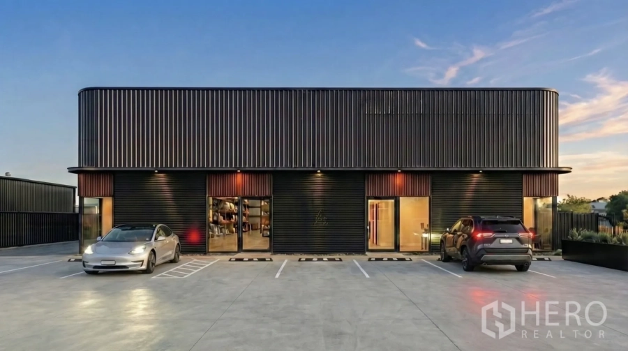 Warehouse for rent in Suan Luang, Bangkok - Evening facade of contemporary warehouse block with roller shutters and marked parking bays.