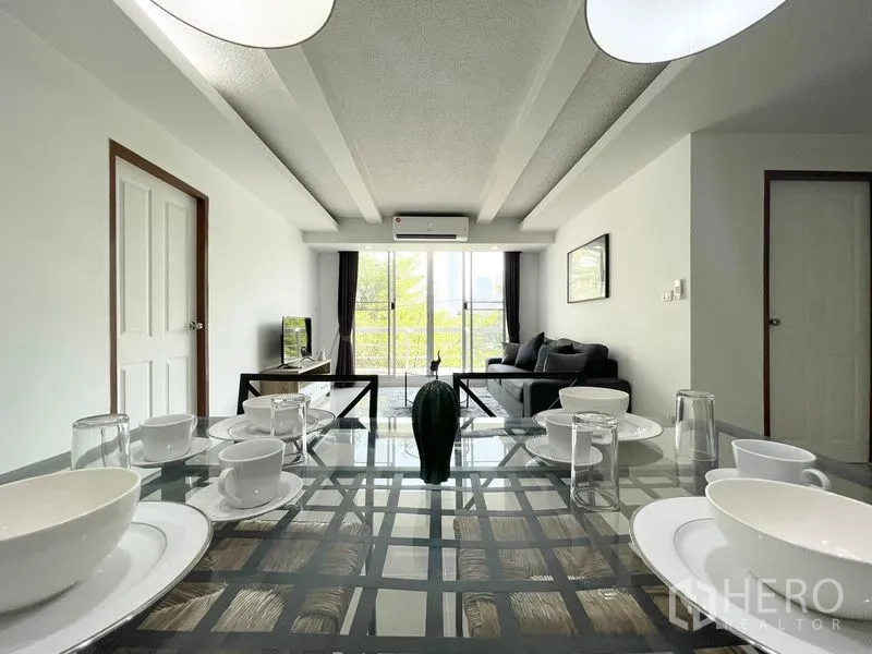 Condominium for rent in Khlong Toei, Bangkok - Open view from dining area toward living room and balcony beyond.