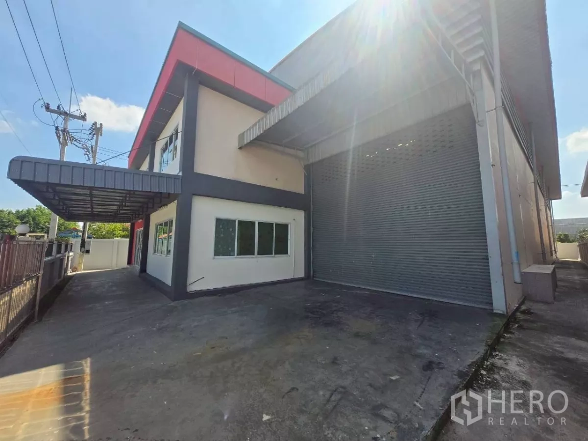 Factory for rent or sale in Mueang Samut Sakhon, Samut Sakhon - Loading bay with a large roller shutter door beside the two-storey office wing of the warehouse.