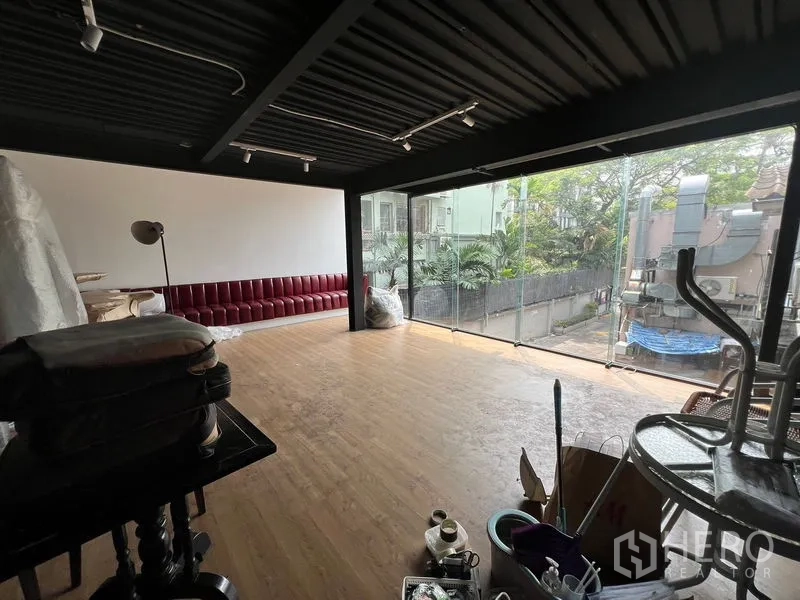 Retail Space for rent - Loft-style retail interior with timber floors, a street-facing glass wall, and a built-in red banquette.