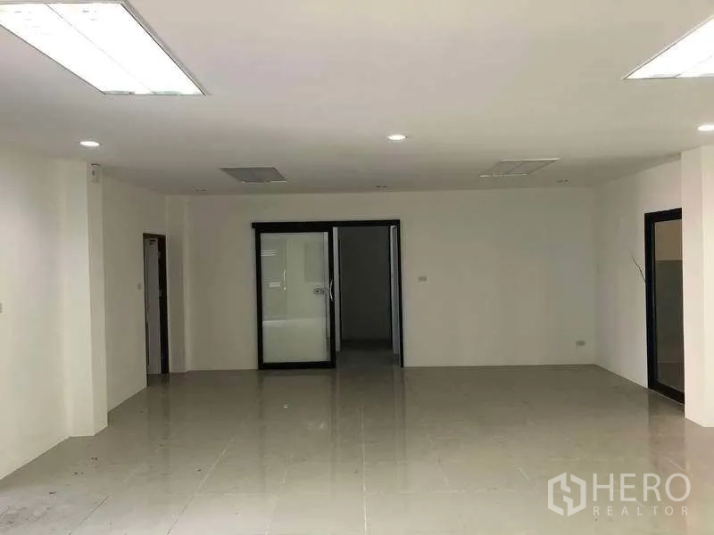 Factory for rent or sale in Samut Prakan - Another view of the spacious office area with sliding doors and ceiling lights.