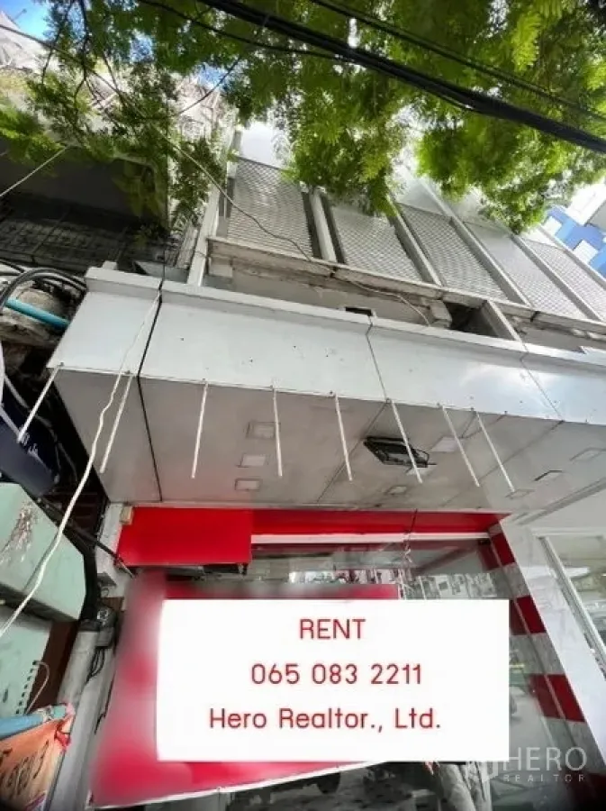 店屋 出租在Khlong Toei, Bangkok - 临街店屋外立面，玻璃门头与金属雨棚、卷闸门，绿树成荫，位于娜娜片区。