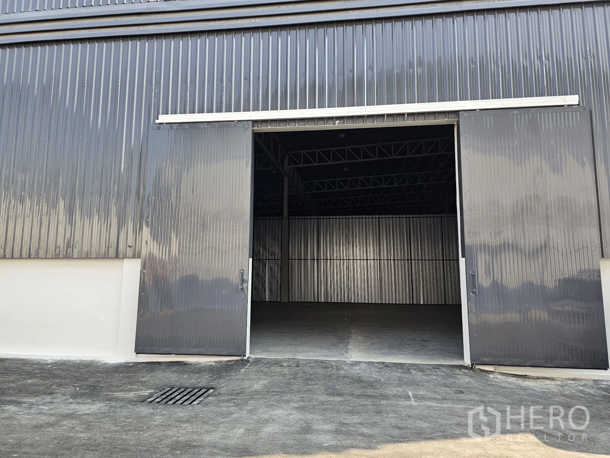 Warehouse for rent in Khlong Toei, Bangkok - Warehouse exterior with wide sliding metal doors opening to driveway.