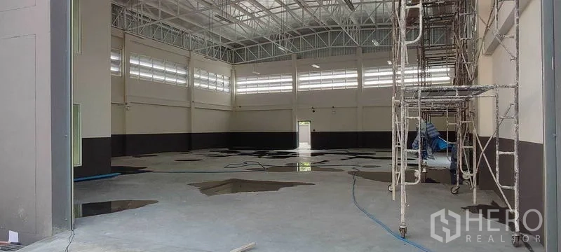 Warehouse for rent in Bang Khun Thian, Bangkok - Spacious high-ceiling warehouse interior with steel truss roof, clerestory windows and concrete floor.